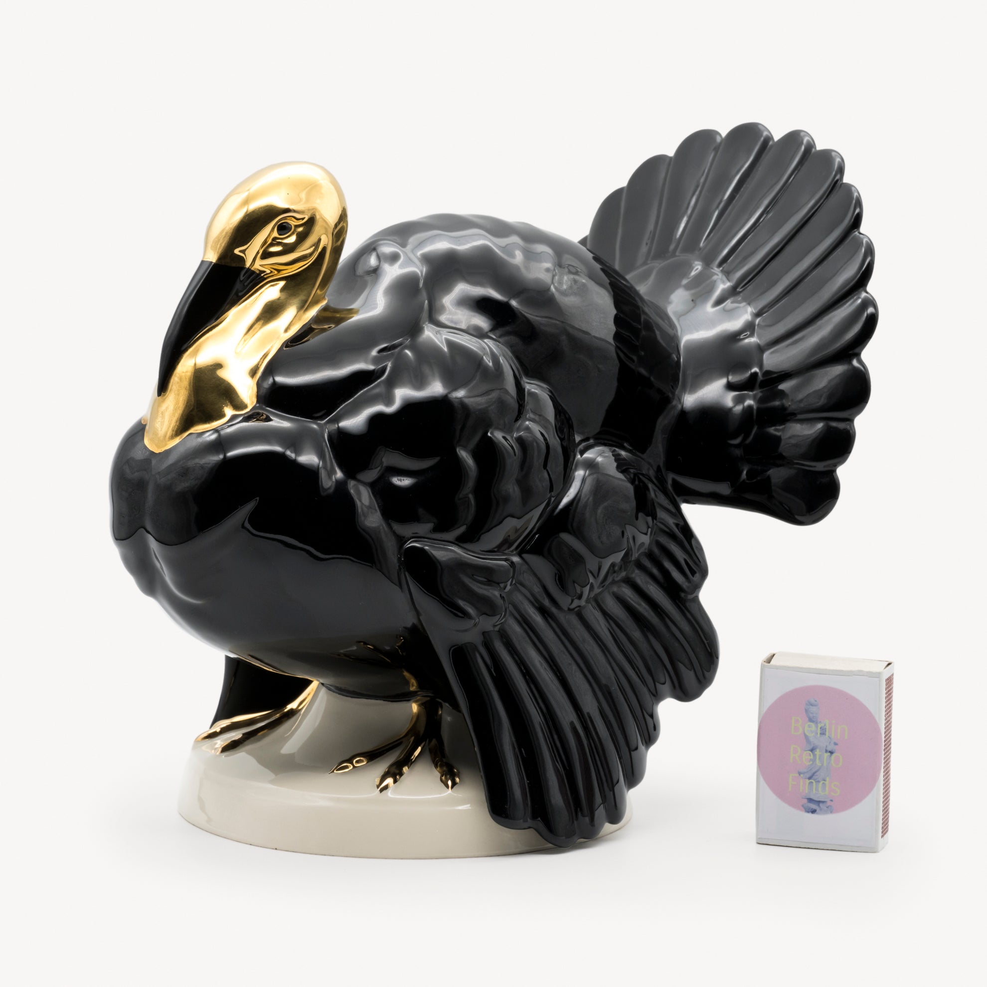 Black and gold Goebel porcelain turkey sculpture photographed with a small box to indicate scale.